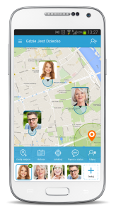 Biały telefon ze screenem z mapy, na której zaznaczone są miniaturami zdjęć miejsca pobytu 3 osób w usłudze Gdzie Jest Dziecko